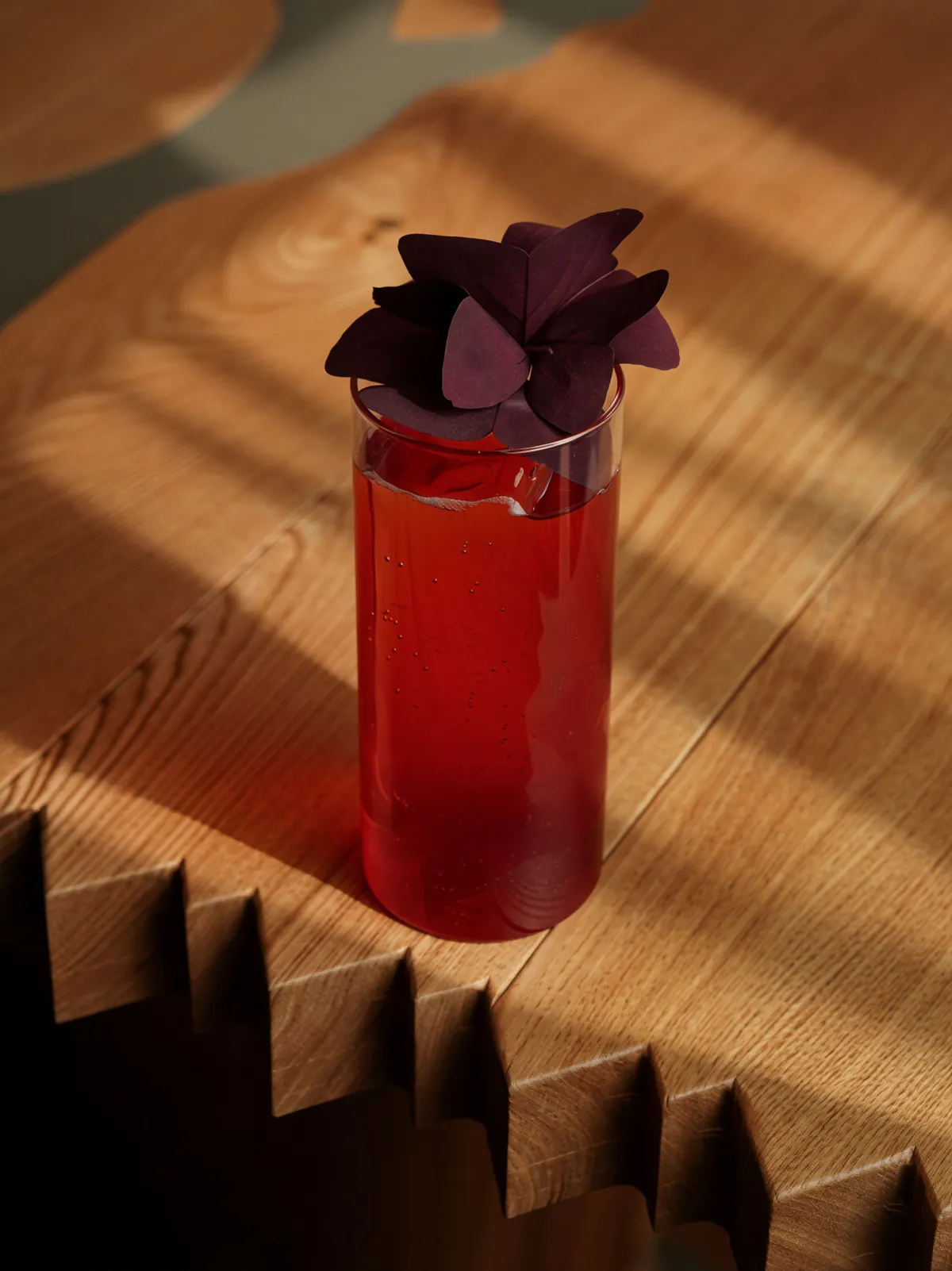 Cóctel rojo adornado con una flor tropical