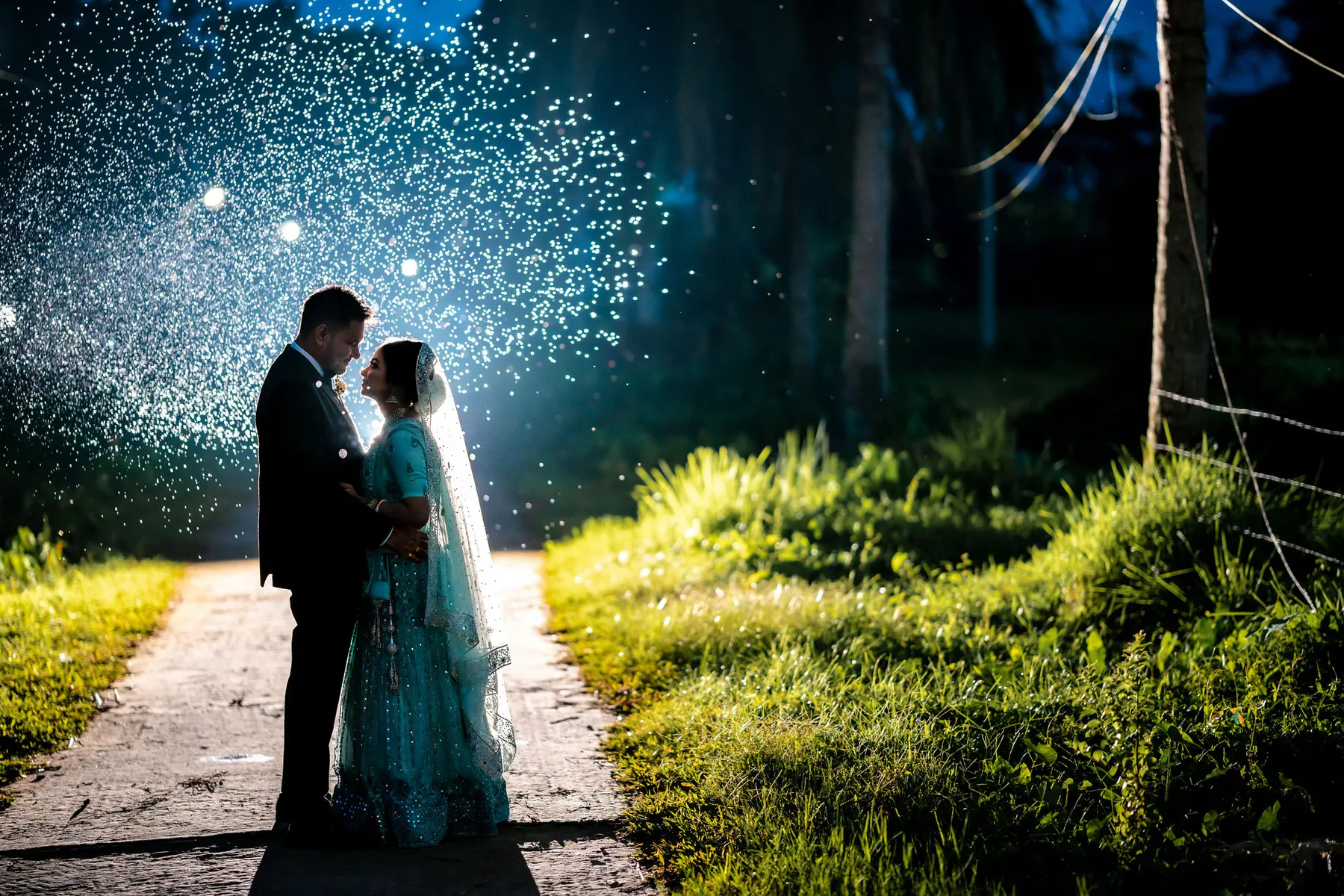 Pareja bajo una lluvia iluminada en la noche