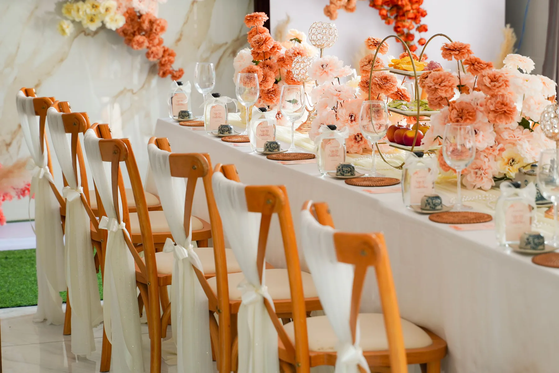 Mesa de recepción marfil con cristalería y flores melocotón
