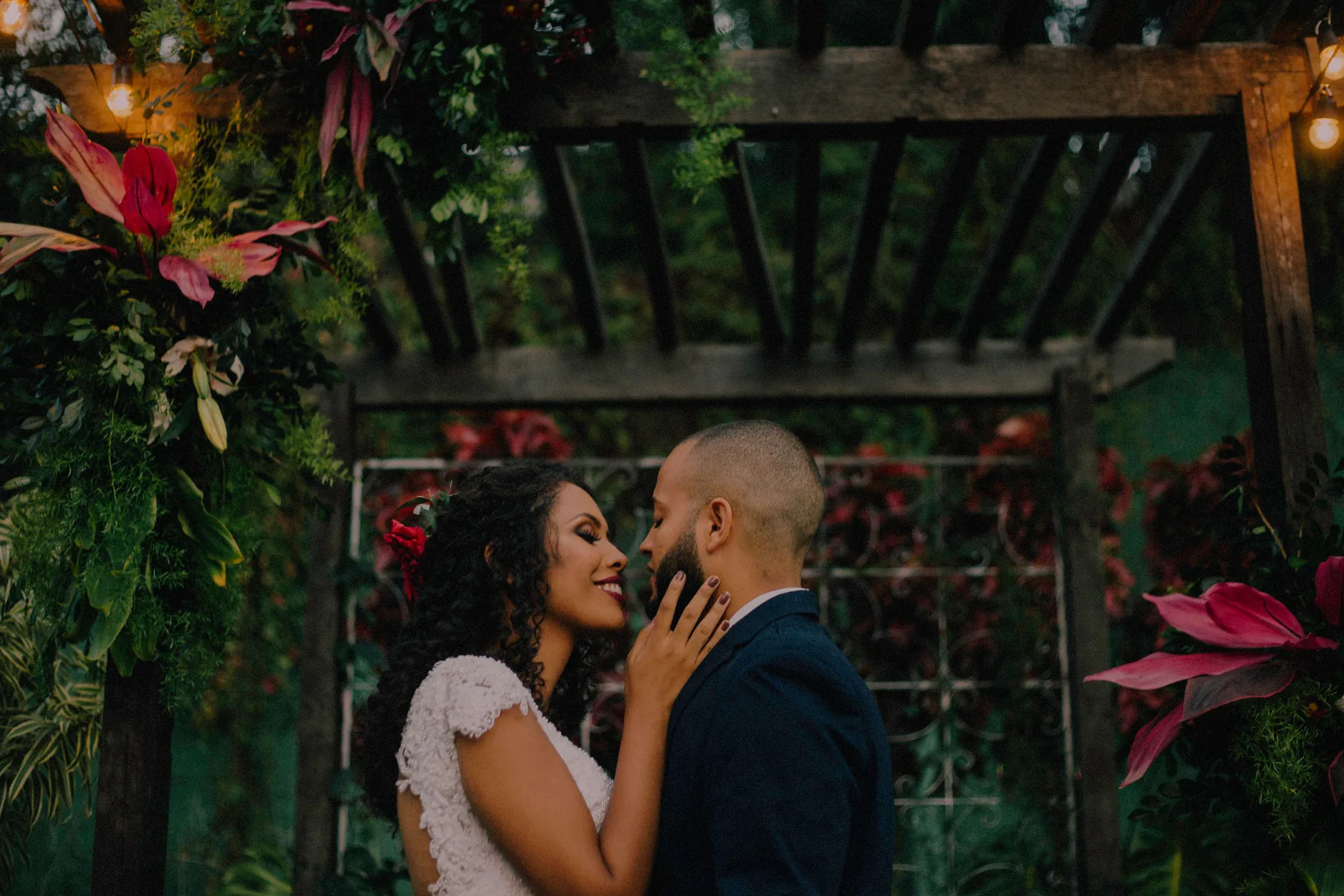 Pareja celebrando bajo un arco floral de jardín