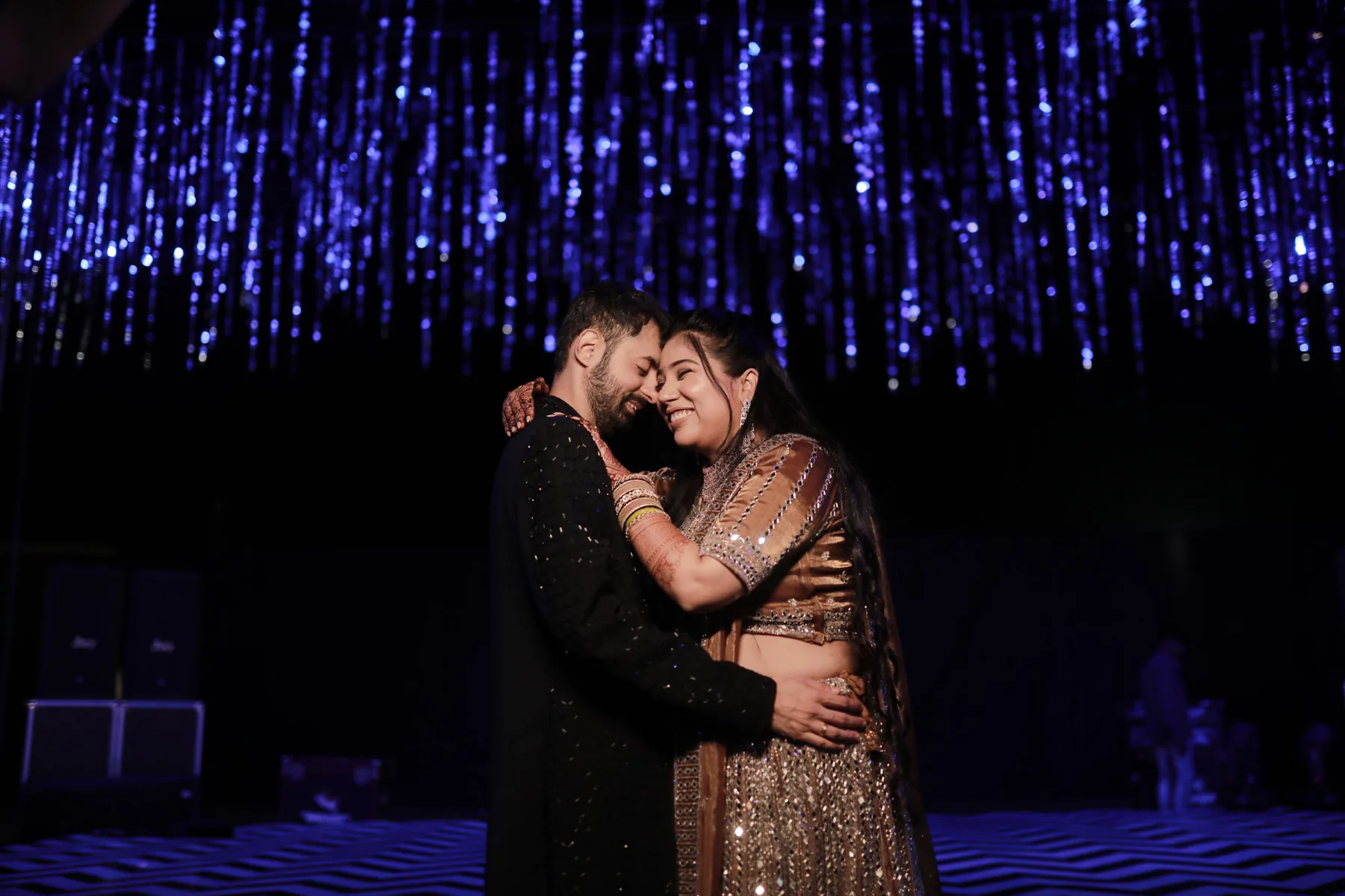 Pareja celebrando bajo una lluvia de luces azules