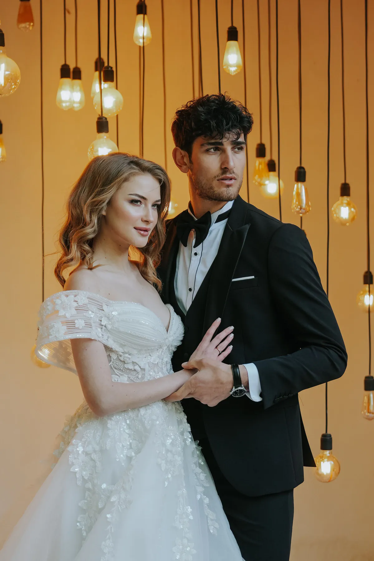 Pareja formal rodeada de luces suspendidas