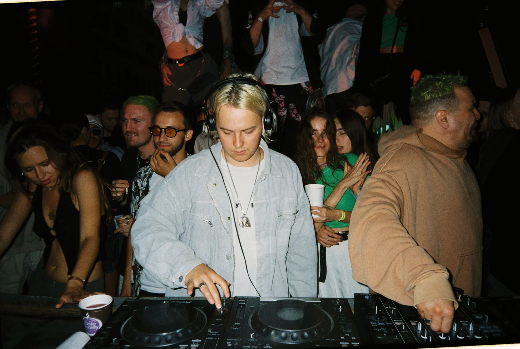 DJ frente a una pista llena fotografiada con flash