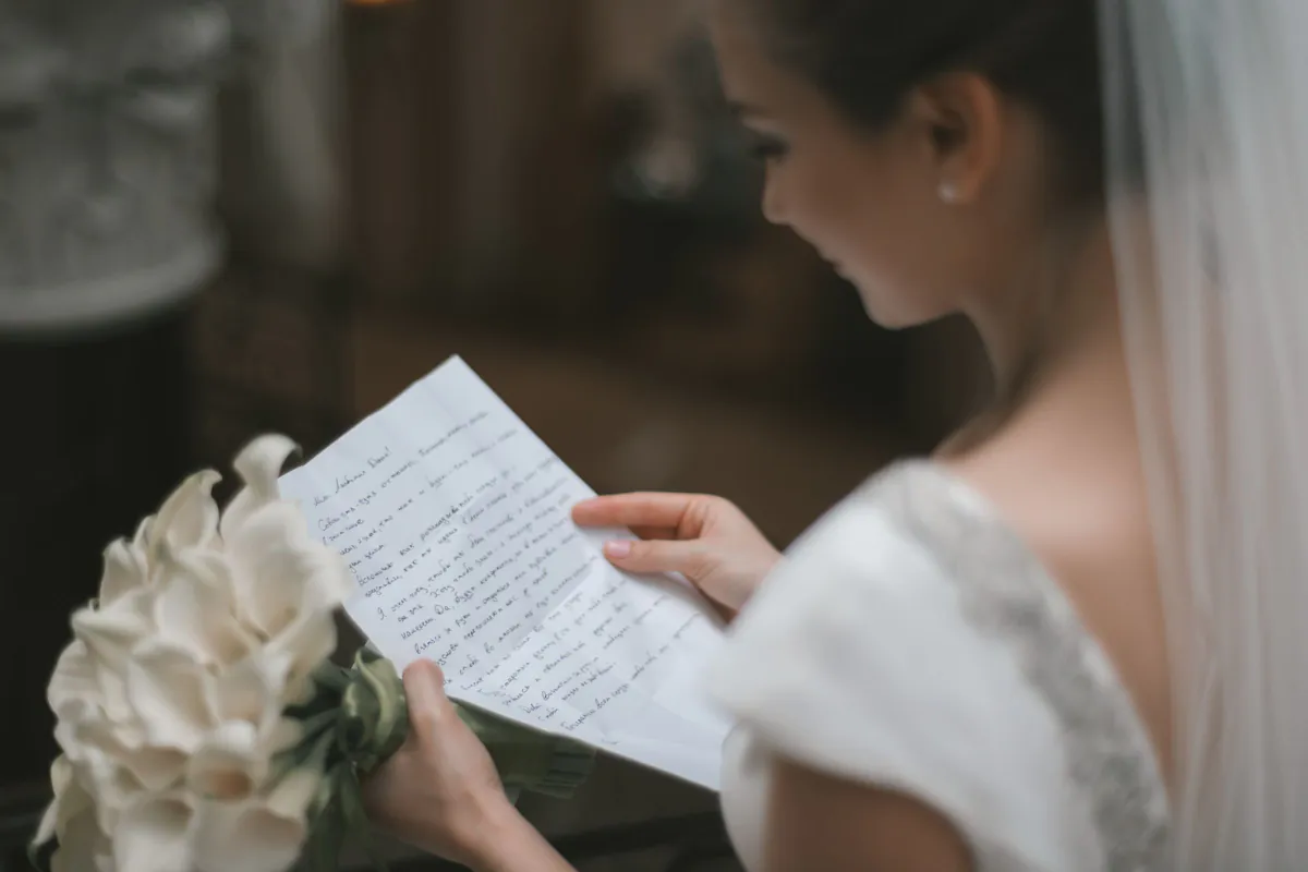 Novia sosteniendo una carta y un ramo