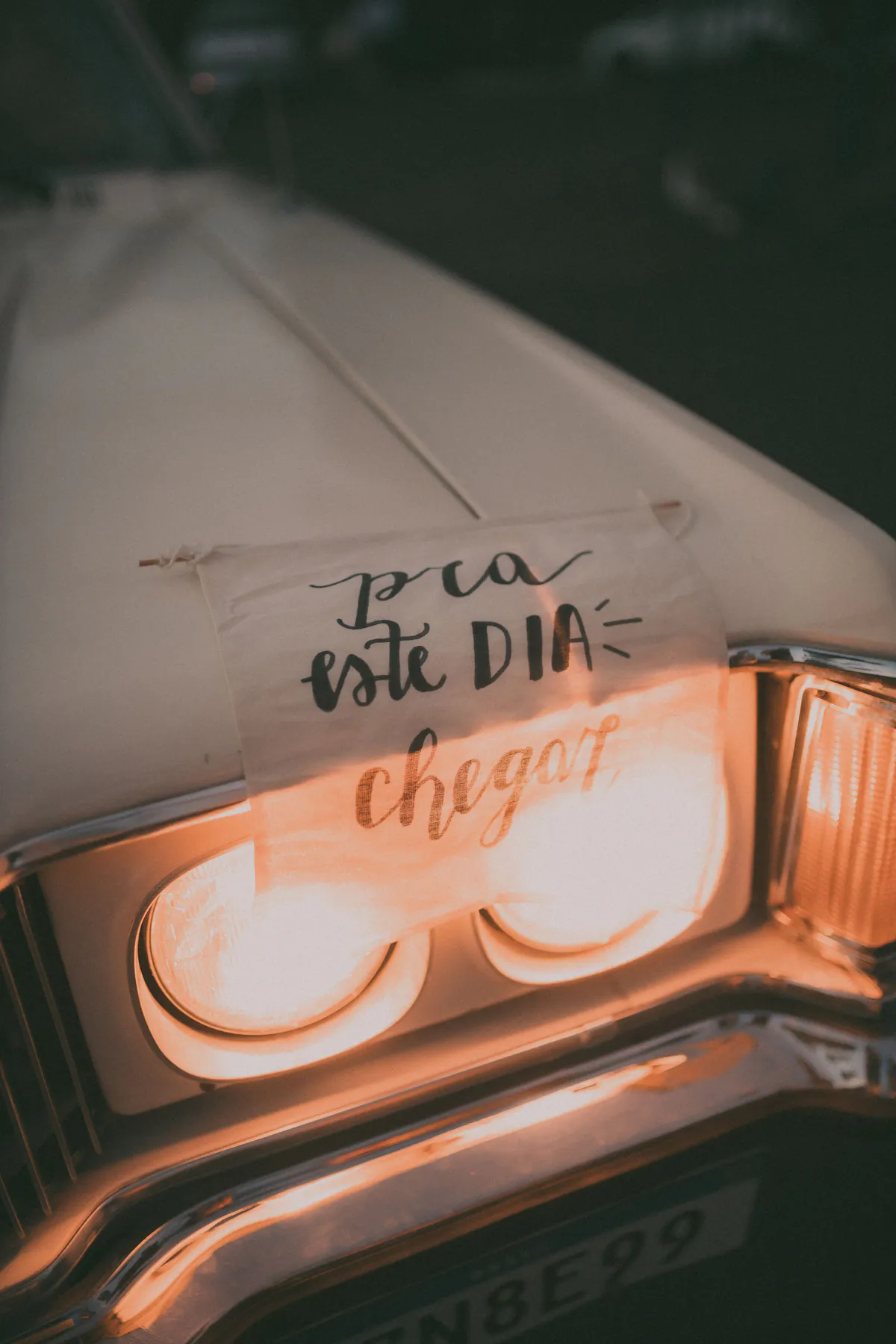 Detalle de un automóvil clásico junto a una nota manuscrita
